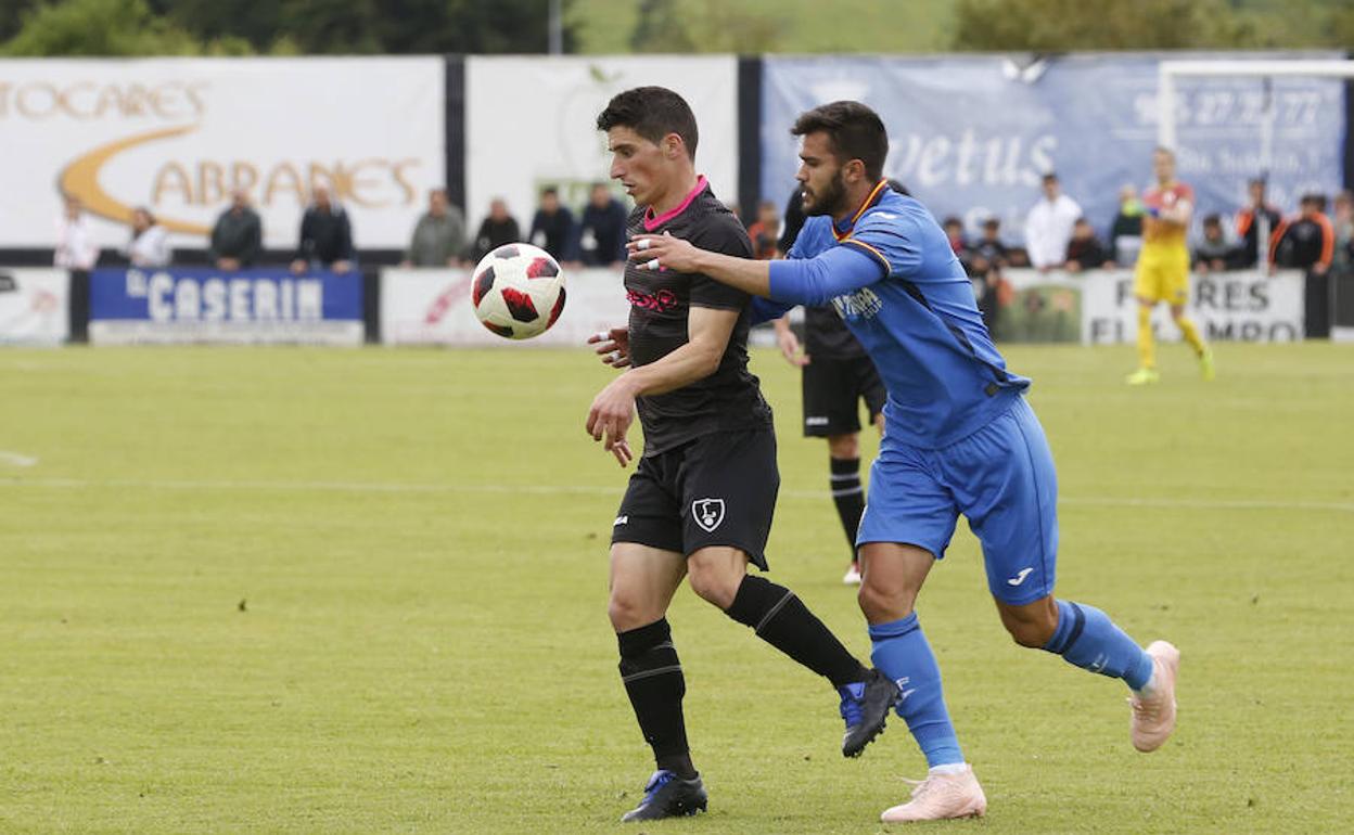 El jugador del Lealtad Jorge se lleva un balón ante un futbolista del Getafe B.