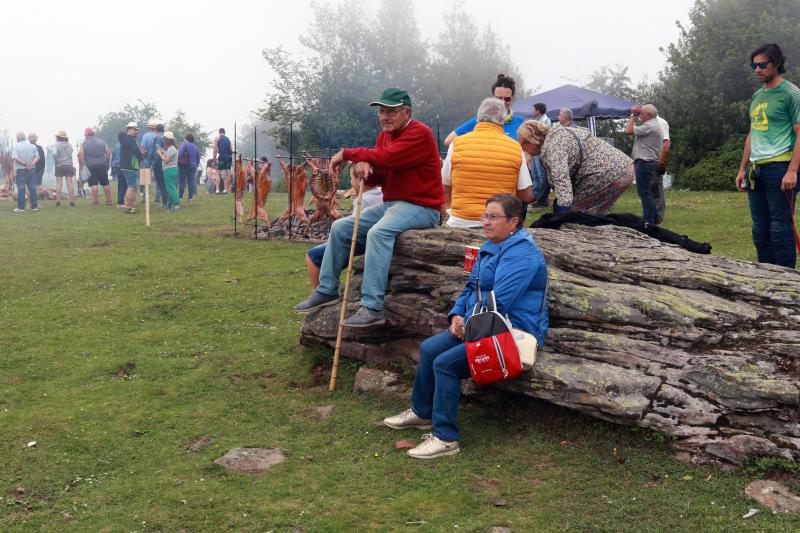 Centenares de personas han disfrutado en el prau Llagüezos del tradicional cordero a la estaca, plato principal de la fiesta de hermanamiento que se organiza entre los concejos de Quirós y Lena. A pesar de que la niebla ha cubierto buena parte de la celebración, el buen ambiente no se ha visto afectado.