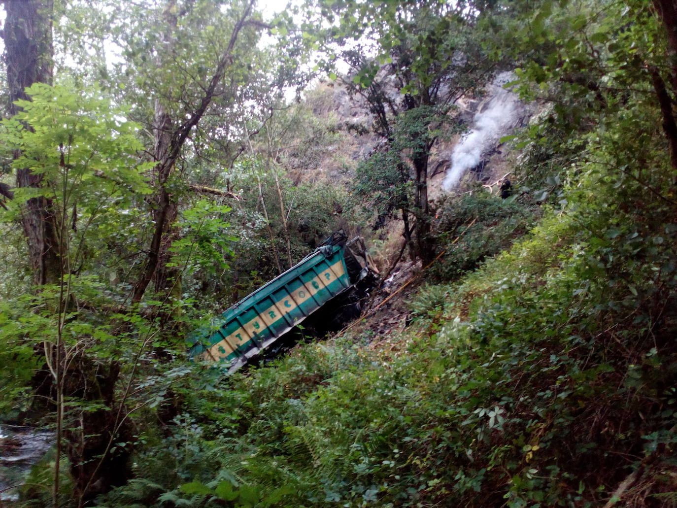 Fallece un vecino de Luarca que transportaba material para arreglar una carretera tras precipitarse con su camión por un desnivel de 25 metros en Villayón. Su camión comenzó a arder, provocando un pequeño incendio forestal.