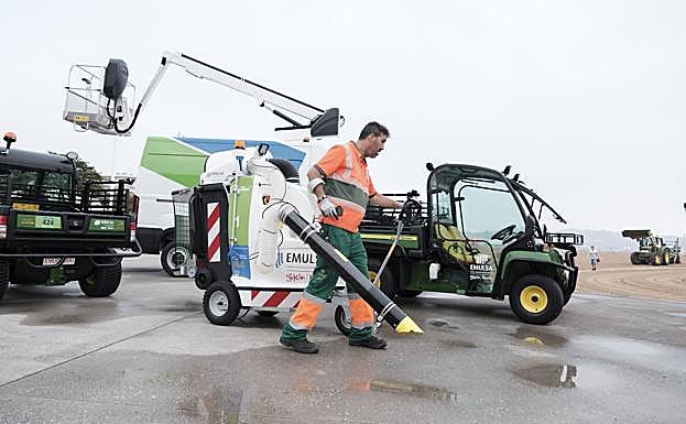 Operario de Emulsa limpian las inmediaciones de la playa de Poniente. 