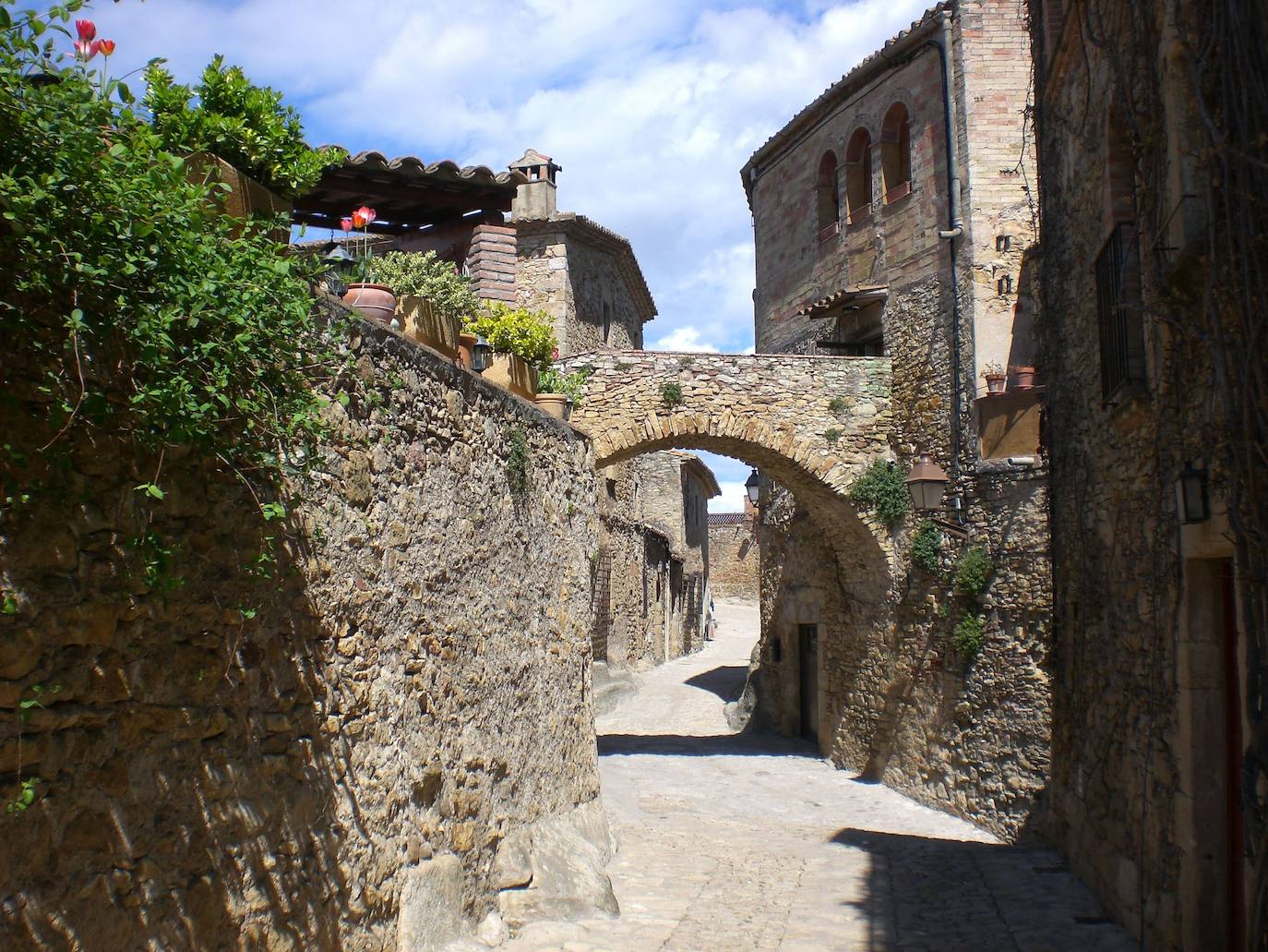 Peratallada (Girona): Este pueblo catalán es un auténtico viaje a la Edad Media. O a la Toscana italiana. Así lo han descrito aquellos que han tenido oportunidad de conocer este escondite. Un tramo pequeño de muralla con un arco avisa de la llegada al pueblo. Sus calles, a modo de laberinto, de piedra y su castillo de cuento son dos de los platos fuertes del municipio. Pero, otra de las imágenes más repetidas son las enredaderas que crecen en muros y ventanas.