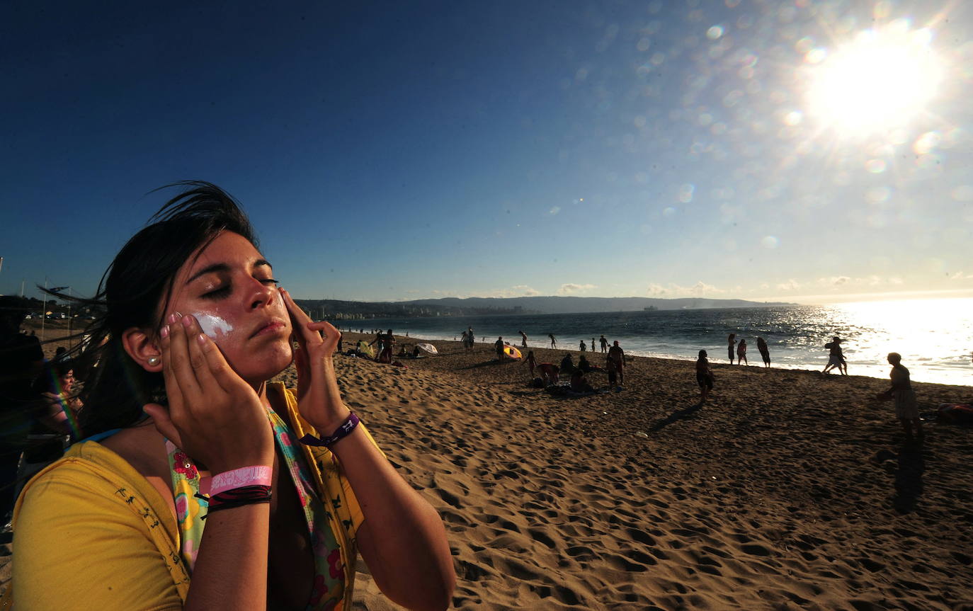 Una mujer se echa crema en el rostro durante una jornada en la playa 