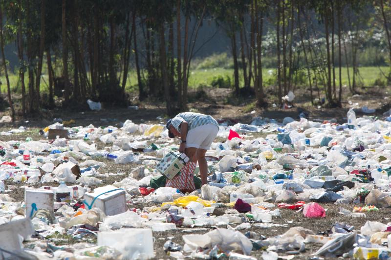 La multitudinaria fiesta del Xiringüelu ha dejado toneladas de basura en el prau Salcéu. Botellas, vasos, y restos de las coloridas casetas que son seña de identidad de la celebración han quedado esparcidos por el campo a la espera de que se retiren, unas labores que ya han comenzado.