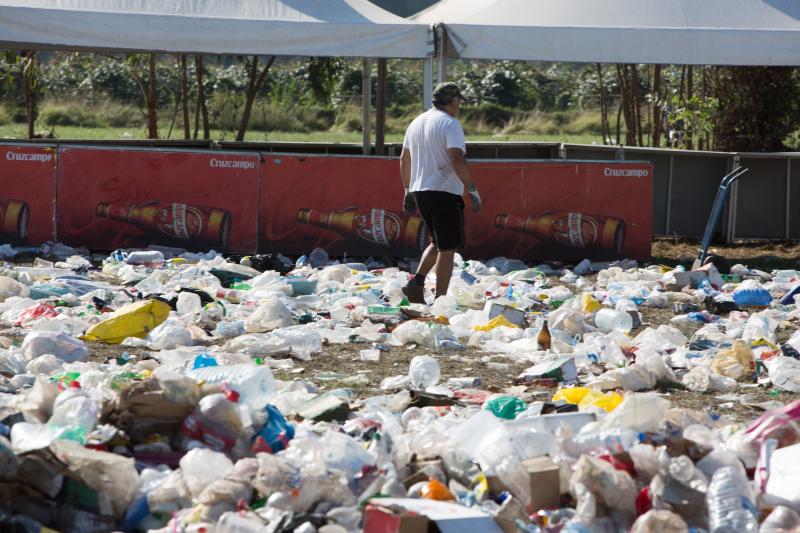 La multitudinaria fiesta del Xiringüelu ha dejado toneladas de basura en el prau Salcéu. Botellas, vasos, y restos de las coloridas casetas que son seña de identidad de la celebración han quedado esparcidos por el campo a la espera de que se retiren, unas labores que ya han comenzado.