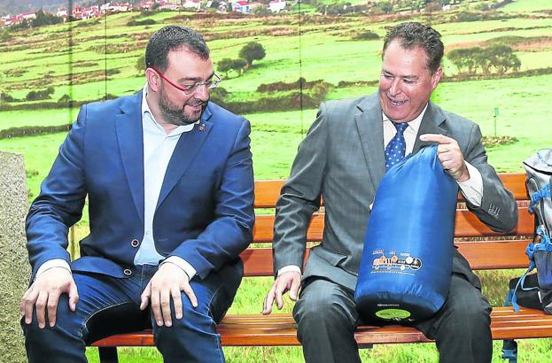 Adrián Barbón y Félix Baragaño posan con Caravia y El Fito de fondo de imagen y el saco y la mochila del peregrino en el Pabellón del Principado, dedicado a las rutas jacobeas.