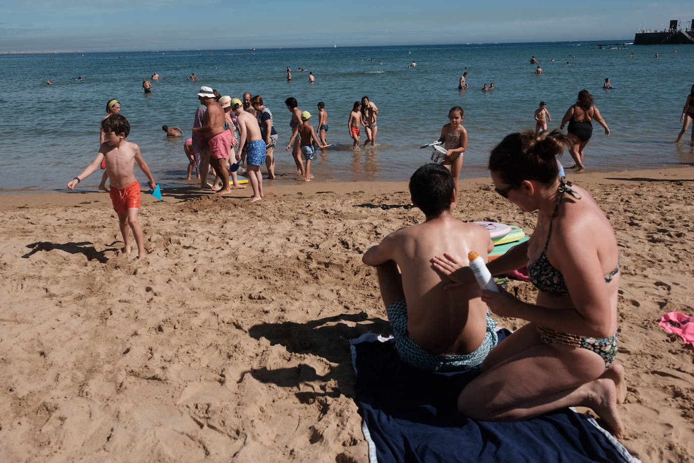 Un baño en la playa para combatir el calor en Gijón