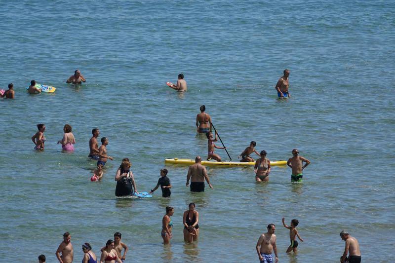 Un baño en la playa para combatir el calor en Gijón