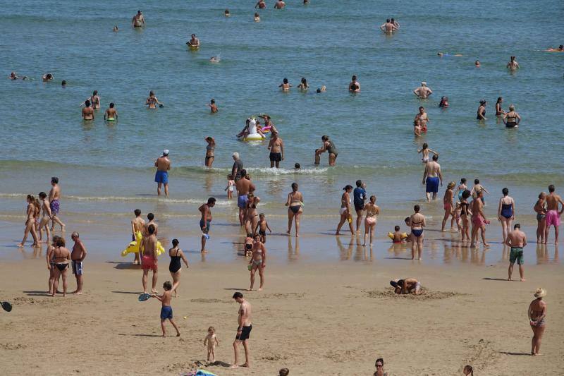 Un baño en la playa para combatir el calor en Gijón