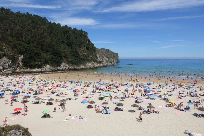 Un baño en la playa para combatir el calor en Gijón