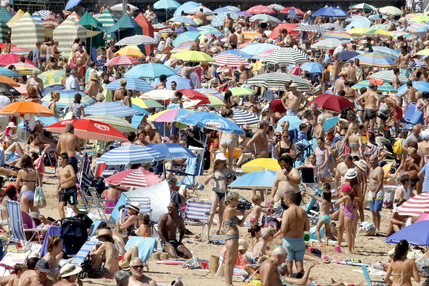 El arenal gijonés se llena en una jornada en la que se superan los 25 grados de temperatura.