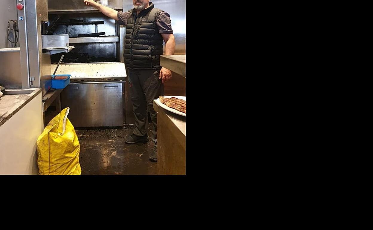 El encargado de la parrilla, Rubén Viña, señala los daños originados tras prenderse la campana. 