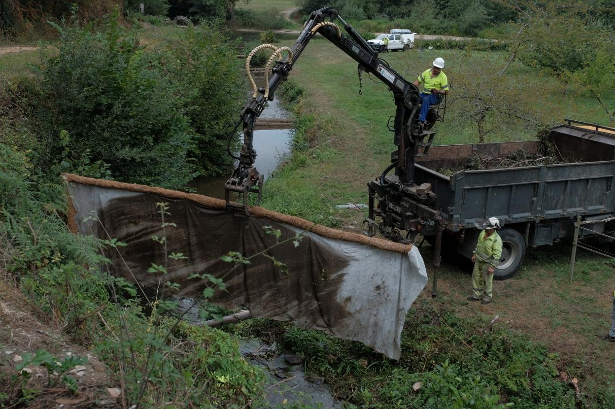 Una de las seis barreras anticontaminación que los operarios de Tragsa instalaron a lo largo de la mañana de ayer en el arroyo Ouria. 