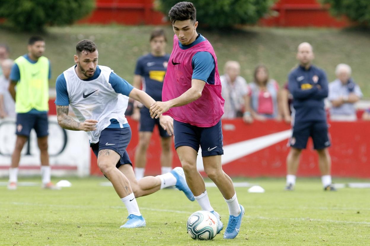 Manu García conduce un balón, en el entrenamiento de ayer, vigilado por el delantero Álvaro Vázquez.