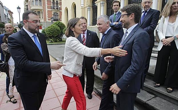 La ministra Reyes Maroto saluda al presidente de Fade, Belarmino Feito, y al consejero de Industria, Enrique Fernández, a su llegada a Oviedo, donde fue recibida por el presidente, Adrián Barbón (izquierda).