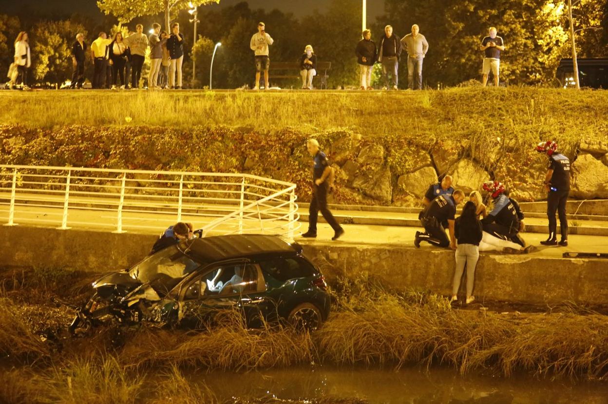 Agentes de la Policía Local atienden al conductor del coche que se precipitó al río Piles el 29 de septiembre de 2018. 