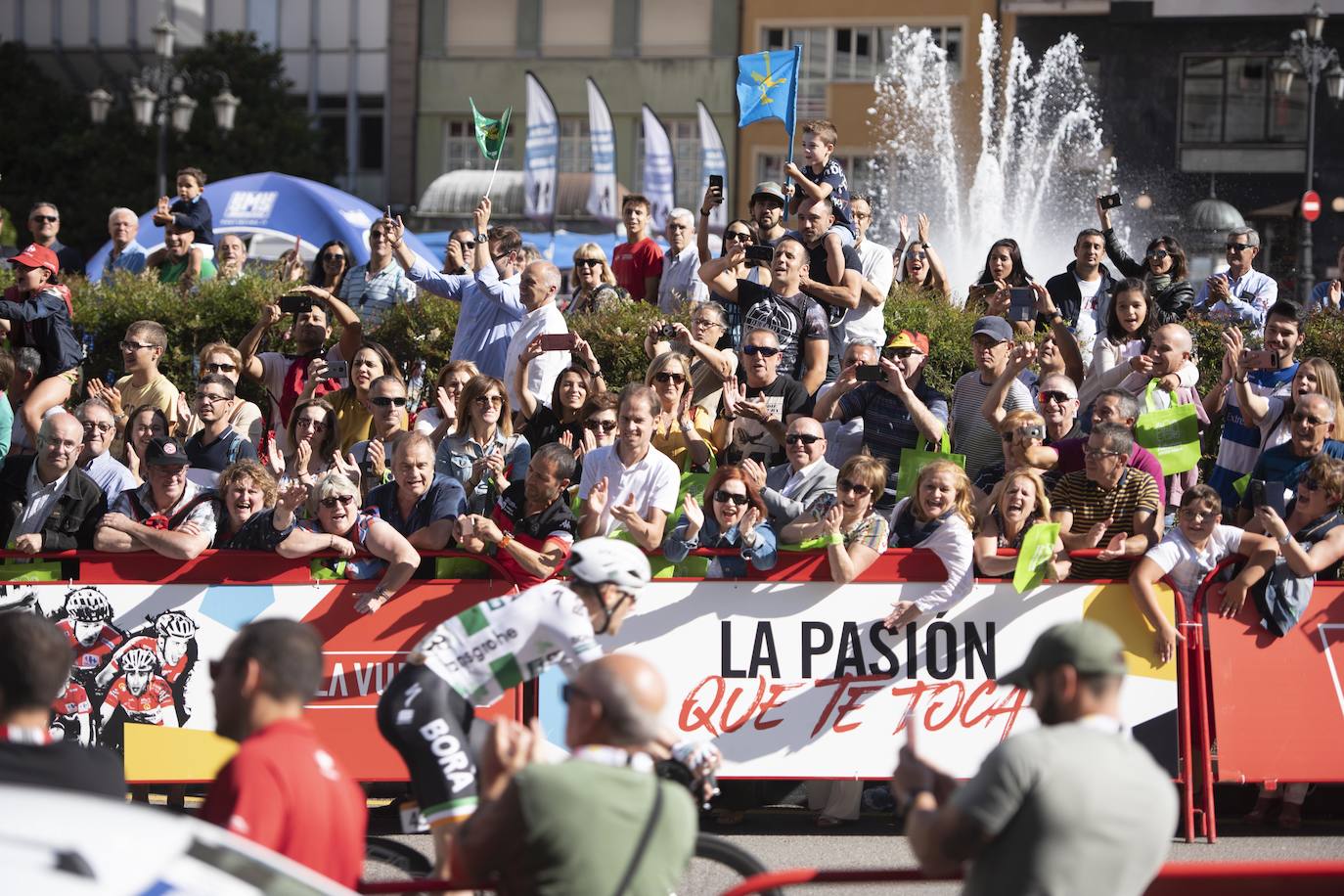 Numerosos aficionados se agolparon en la calle Uría de la capital para ver a los corredores en la etapa 14 entre San Vicente de la Barquera y Oviedo. 