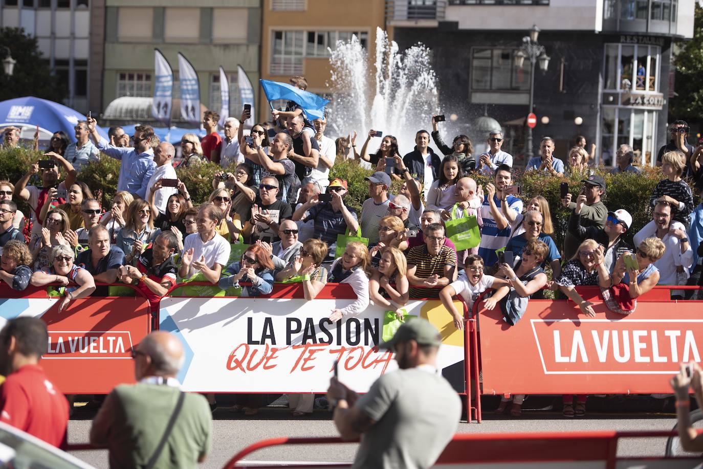 Numerosos aficionados se agolparon en la calle Uría de la capital para ver a los corredores en la etapa 14 entre San Vicente de la Barquera y Oviedo. 
