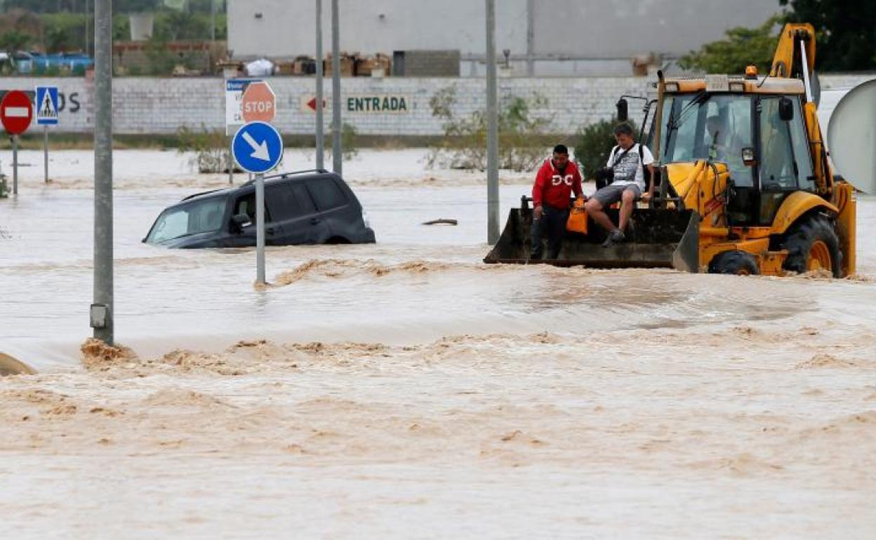 Dos ocupantes de un vehículo son rescatados con una pala mecánica en Orihuela (Alicante).
