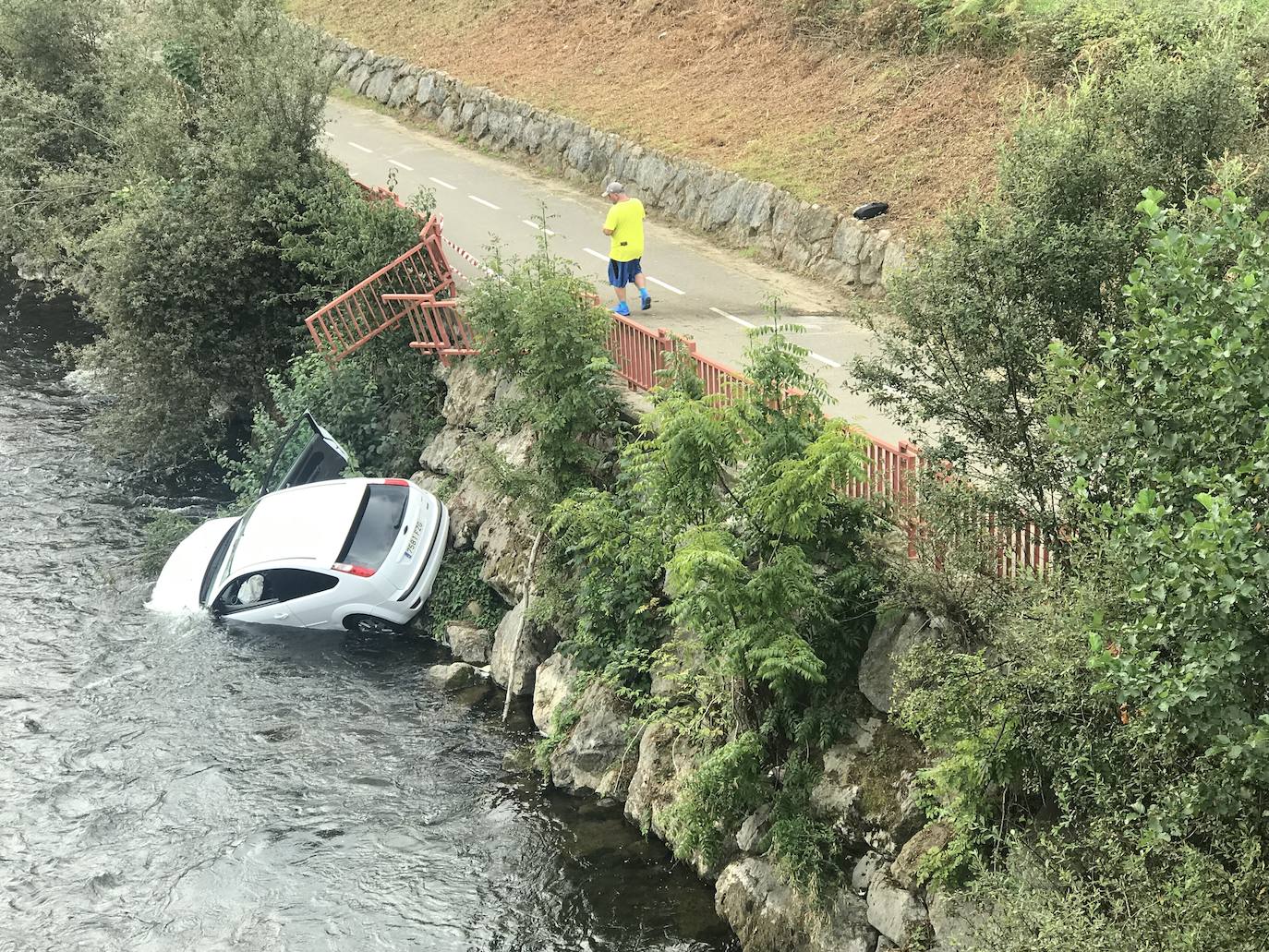 Espectacular accidente con un herido leve. Un coche con cuatro ocupantes que circulaba por la carretera AS-117 ha caído al río Nalón en El Entrego. El conductor triplicaba la tasa de alcoholemia.