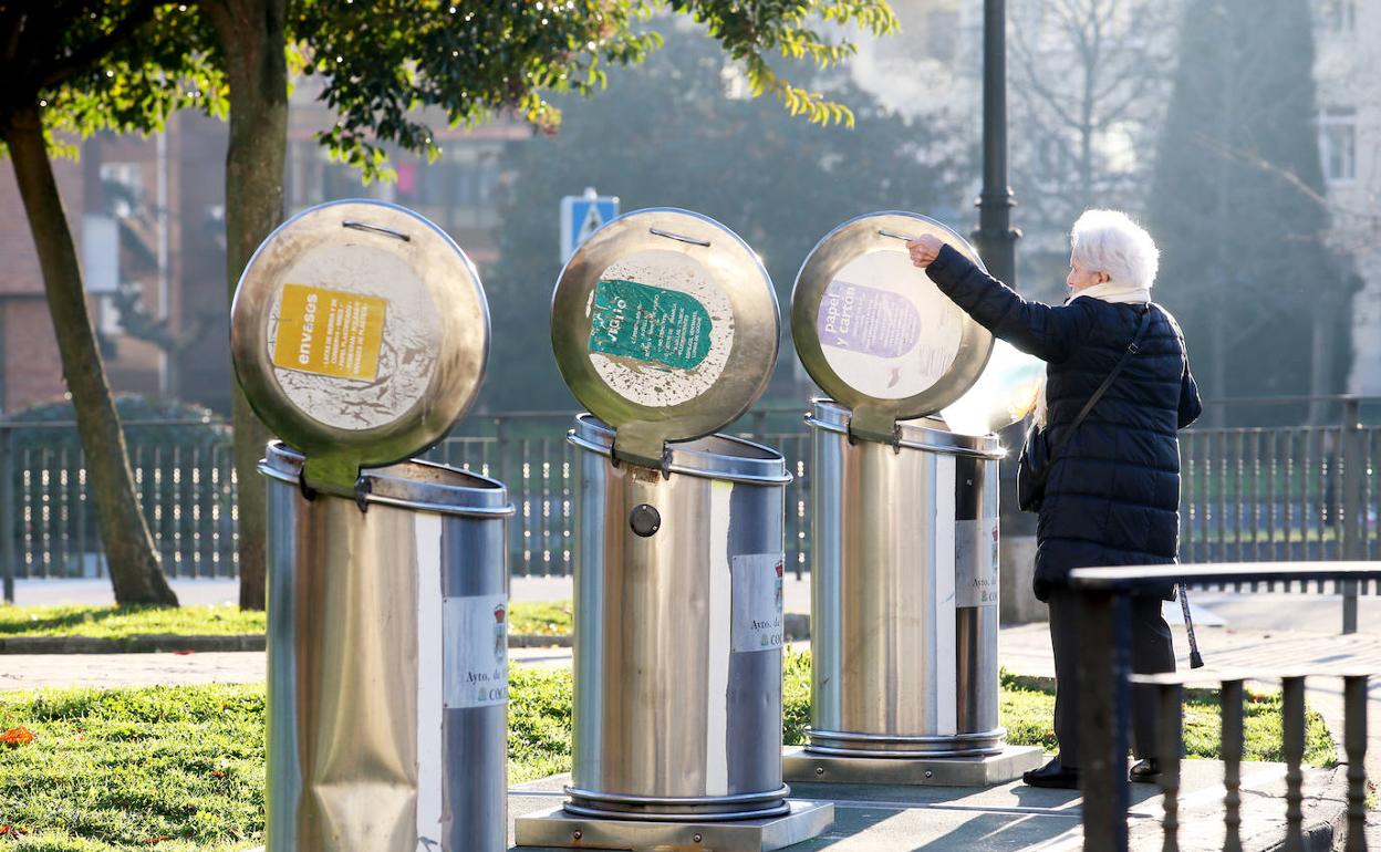 Una vecina en uno de los contenedores instalados en la calle para la recogida selectiva. 