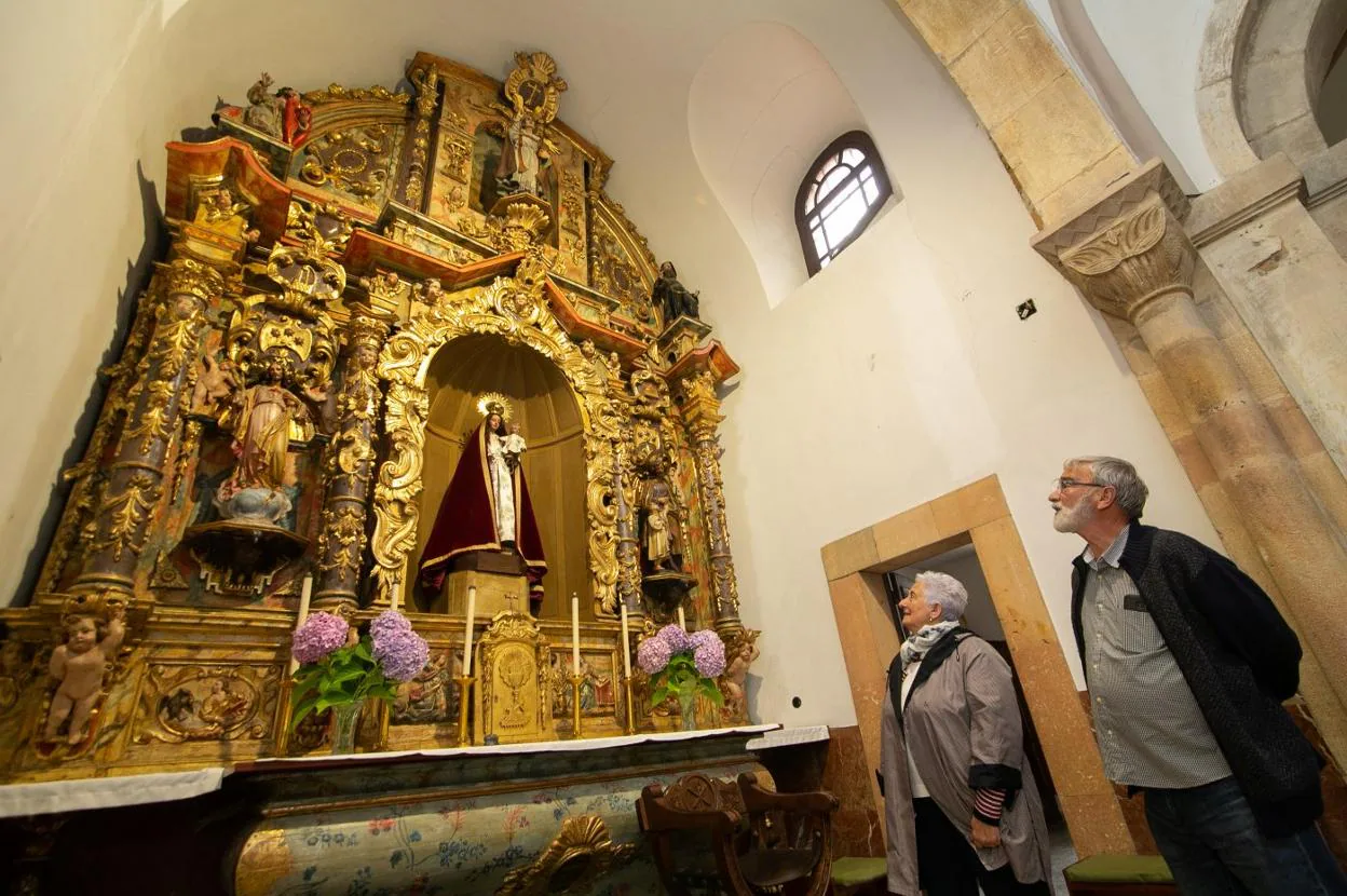 Loli Prendes y José Junquera admiran el retablo barroco de la iglesia de San Martín, situada en la parroquia sierense 