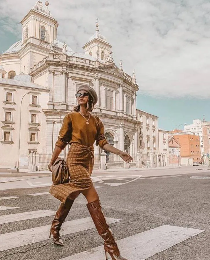 Alexandra Pereira prefiere combinar diferentes tonalidades de marrón, en este look formado por falda de cuadros con abertura, jersey básico y botas altas.