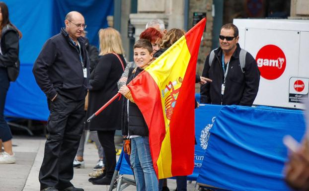 Un niño, con la bandera de España, aguarda la llegada de los invitados. 