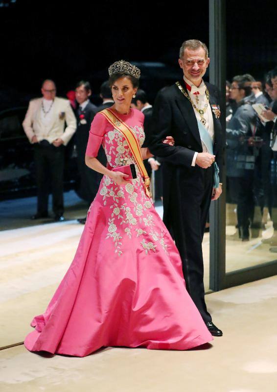 Doña Letizia ha vuelto a convertir en protagonista otro de sus estilismos: un llamativo vestido con estampado de hortensias y fondo verde, que no ha dejado indiferente a nadie, y que ha lucido en su asistencia a la entronización de Naruhito de Japón. Un nuevo estilismo con el que la Reina también ha logrado trasladar la moda de Andalucía a Japón. La prenda pertenece a la diseñadora cordobesa Matilde Cano y en su web se encuentra aún disponible por 339 euros. Para rematar el look, no ha dudado en combinarlocon una diadema de diseño acolchado y en tono rosa claro a juego con su vestido, otra de las tendencias del momento. En el Palacio Imperial, Doña Letizia también ha estrenado otro vestido, en este caso de Carolina Herrera, hecho a medida un diseño de cuerpo entallado, manga francesa y falda de vuelo en color rosa espiga, en el que las flores, en este caso blancas ocupan también una zona destacada en cintura.