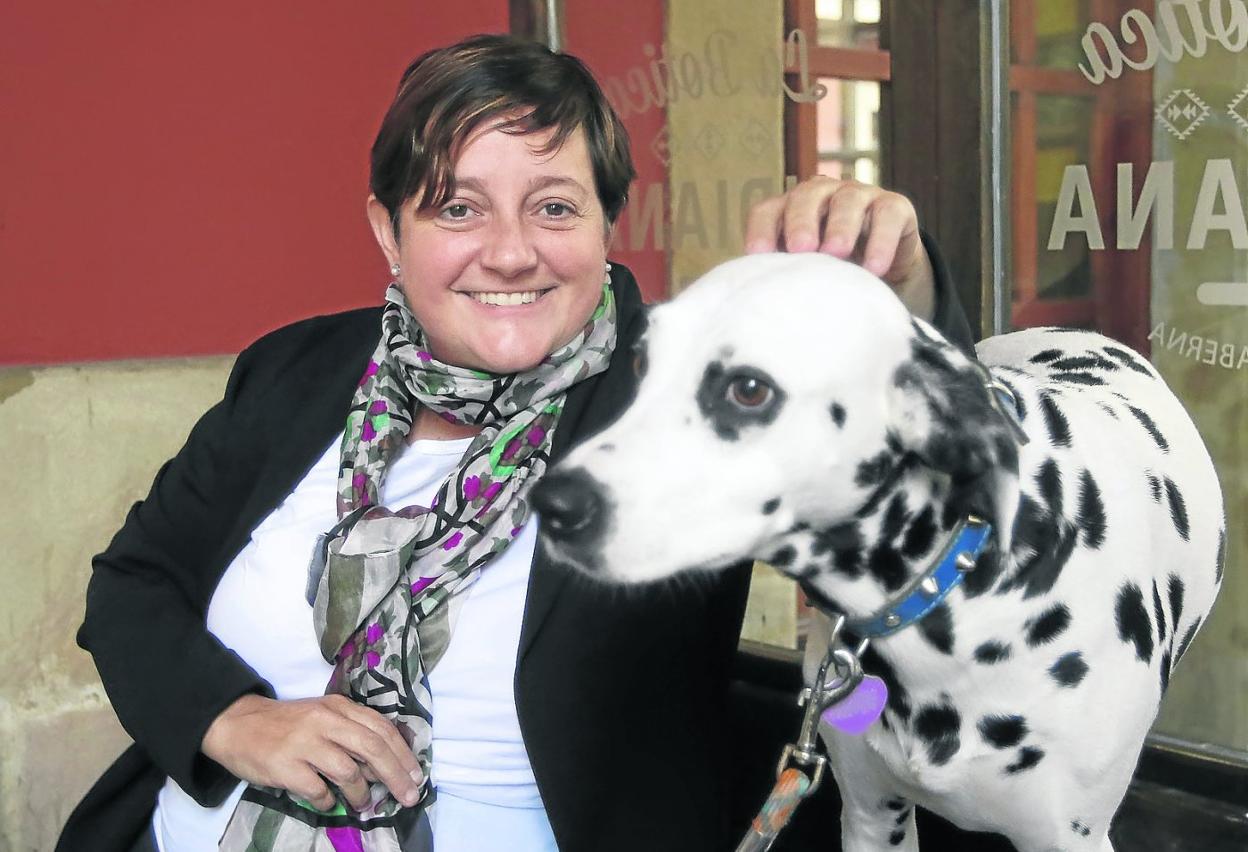 La edil Carmen Saras, en la terraza de La Botica Indiana, acaricia a la dálmata 'Mamba'. 