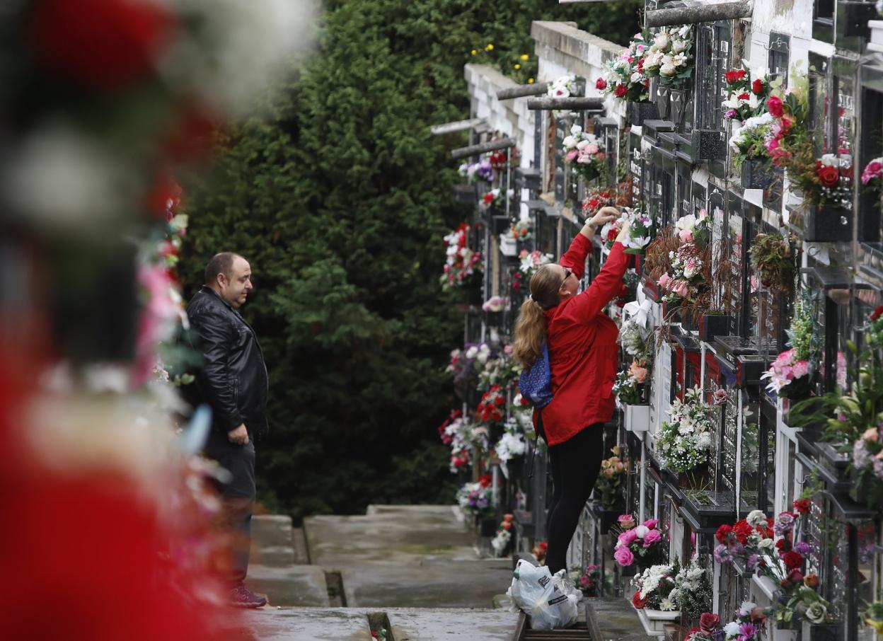 Nichos llenos de flores en Ceares. Mónica Goyanes coloca flores en la tumba de sus abuelos.