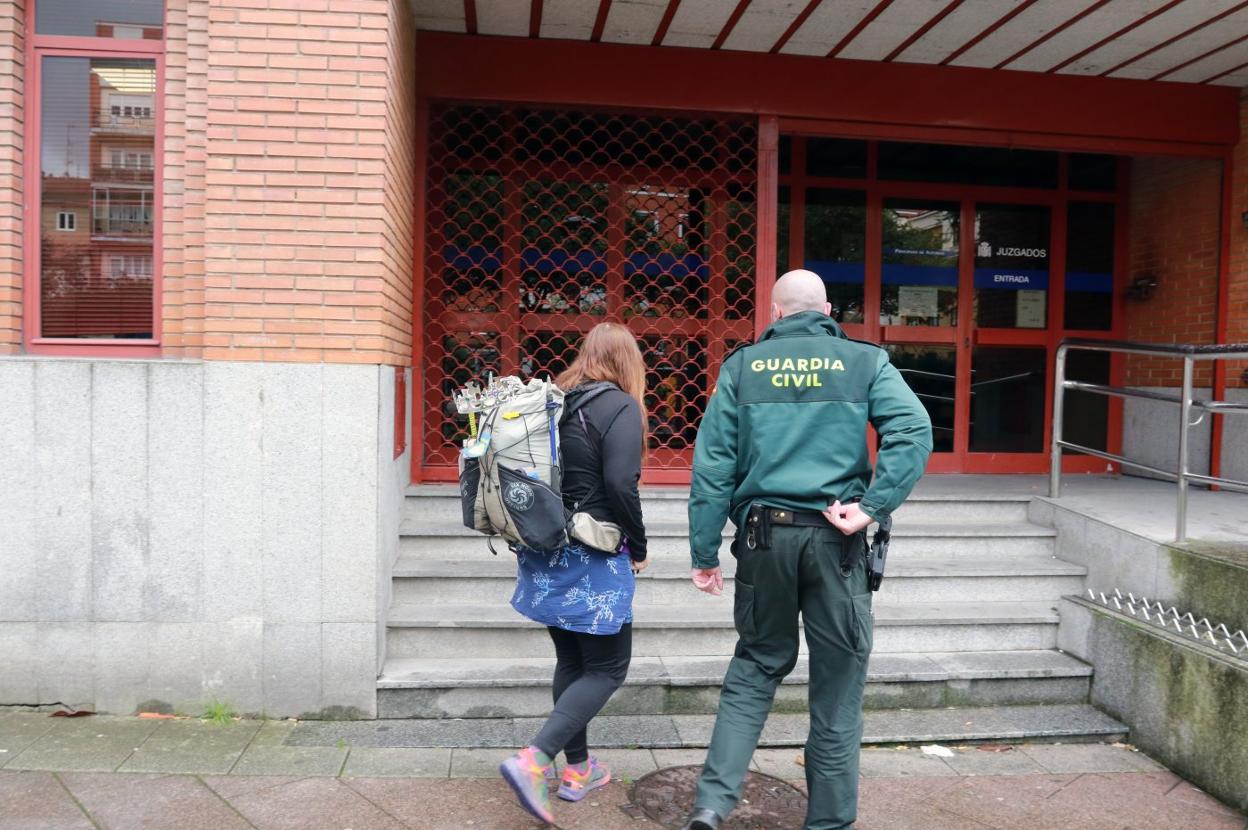 La joven peregrina, a su llegada a los juzgados de Mieres, acompañada de un agente. 