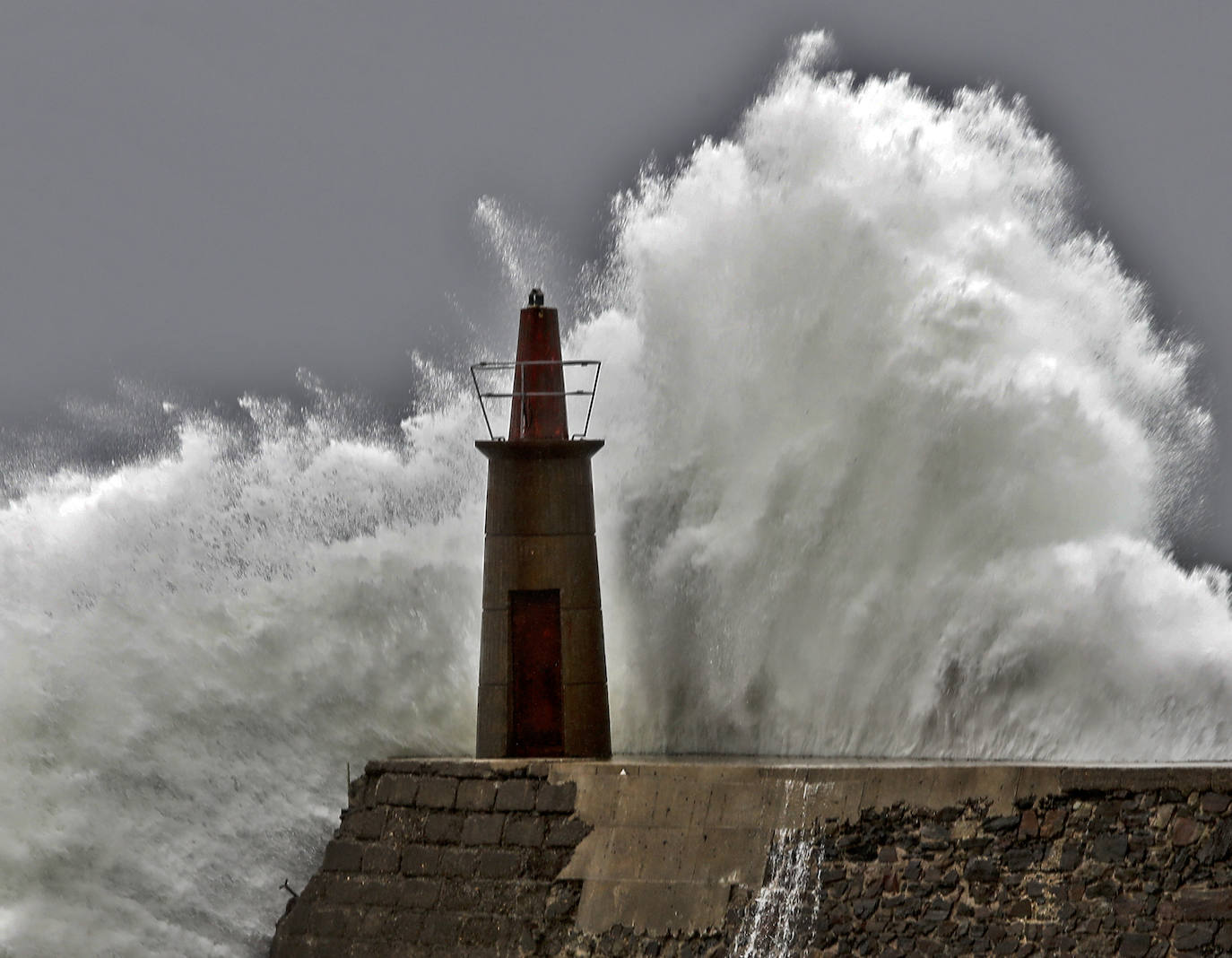 La alerta naranja se está cumpliendo a rajatabla en Asturias, con olas que superan los ocho metros. En el puerto de Viavelez, su faro vuelve a ser protagonista del furioso embate de la mar