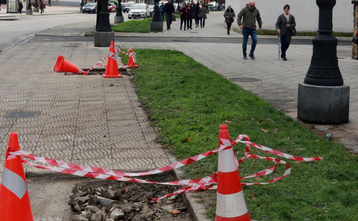 Huecos dejados por dos árboles en una acera de La Felguera. 