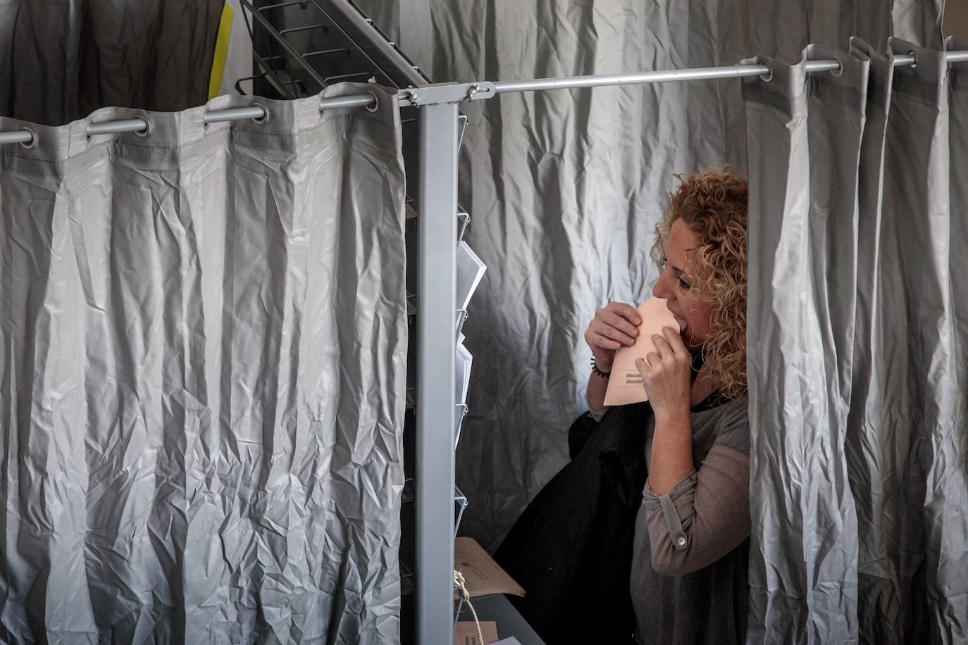 Una mujer cierra el sobre antes de votar en un colegio de Valencia. 
