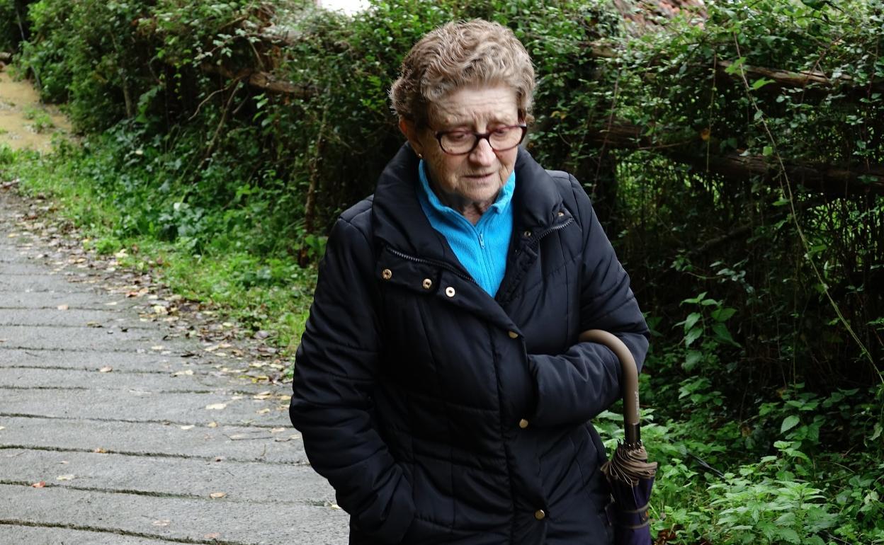 Perfecta María González con su casa tumbada por el argayu. 