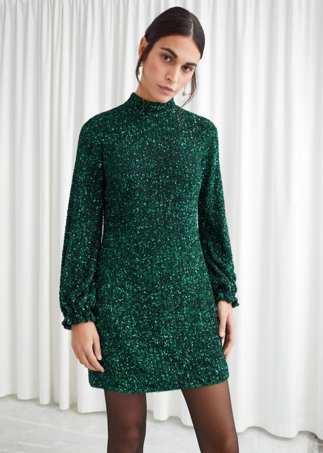 Vestido mini de & Other Stories con lentejuelas en color verde oscuro manga larga y cuello subido, 129 euros.