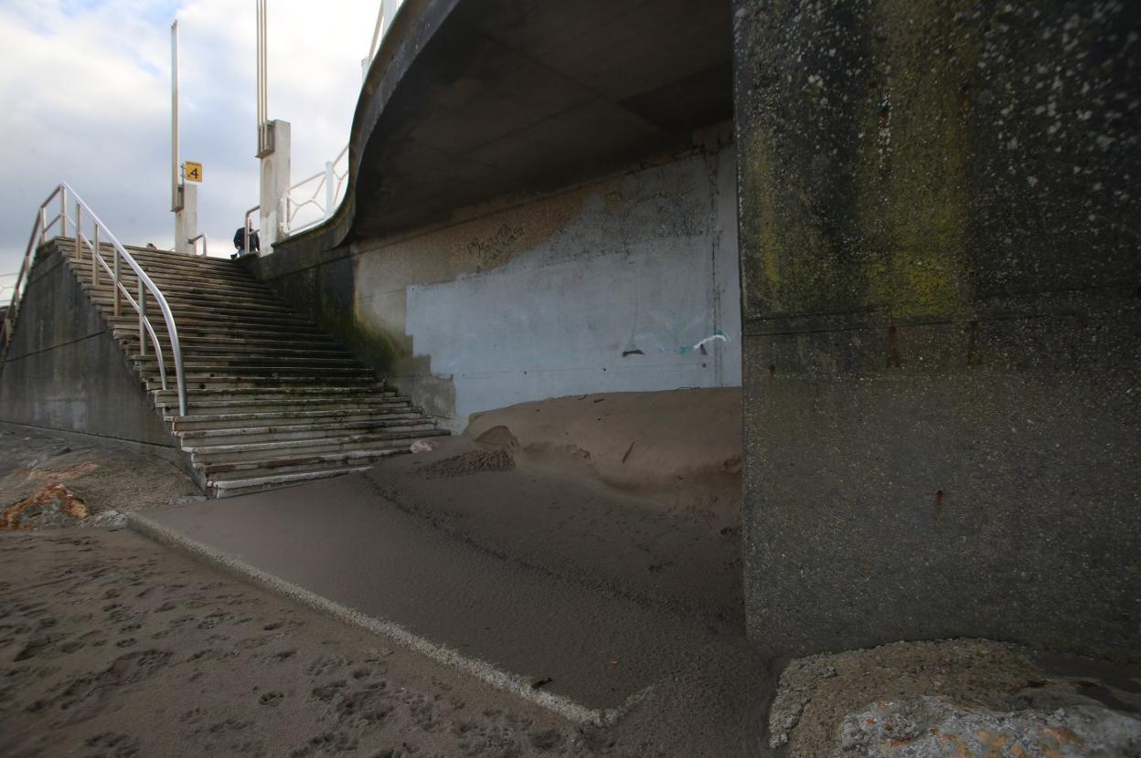 La falta de arena ha dejado al descubierto la base de la escalera y piedras de gran tamaño junto al muro. 