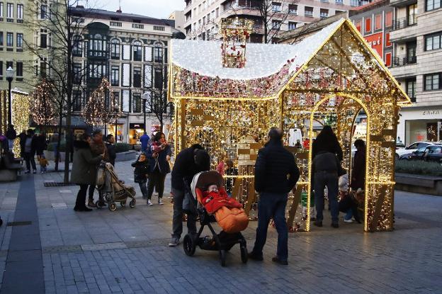 Arriba, la lalcaldesa realiza el encendido en la plaza Mayor. Abajo, el Parchís y la calle Corrida, dos focos navideños. 