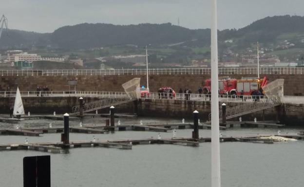 Bomberos y policía en el puerto, durante la intervención.