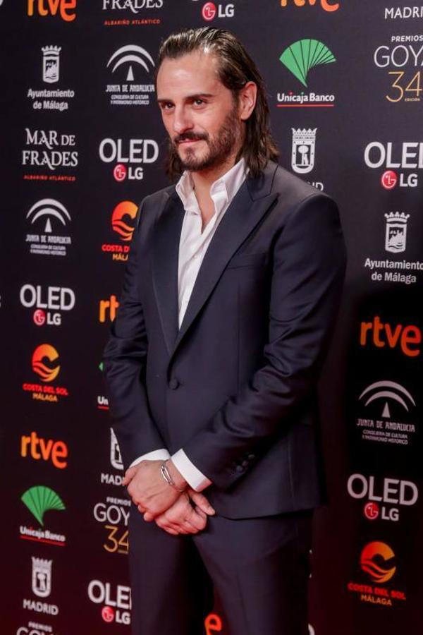 El actor pisó la alfombra roja con un impecable traje negro y una camisa blanca.