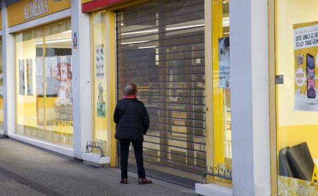 Galería. Una clienta frente al establecimiento de El Molinón antes de que abriera sus puertas.