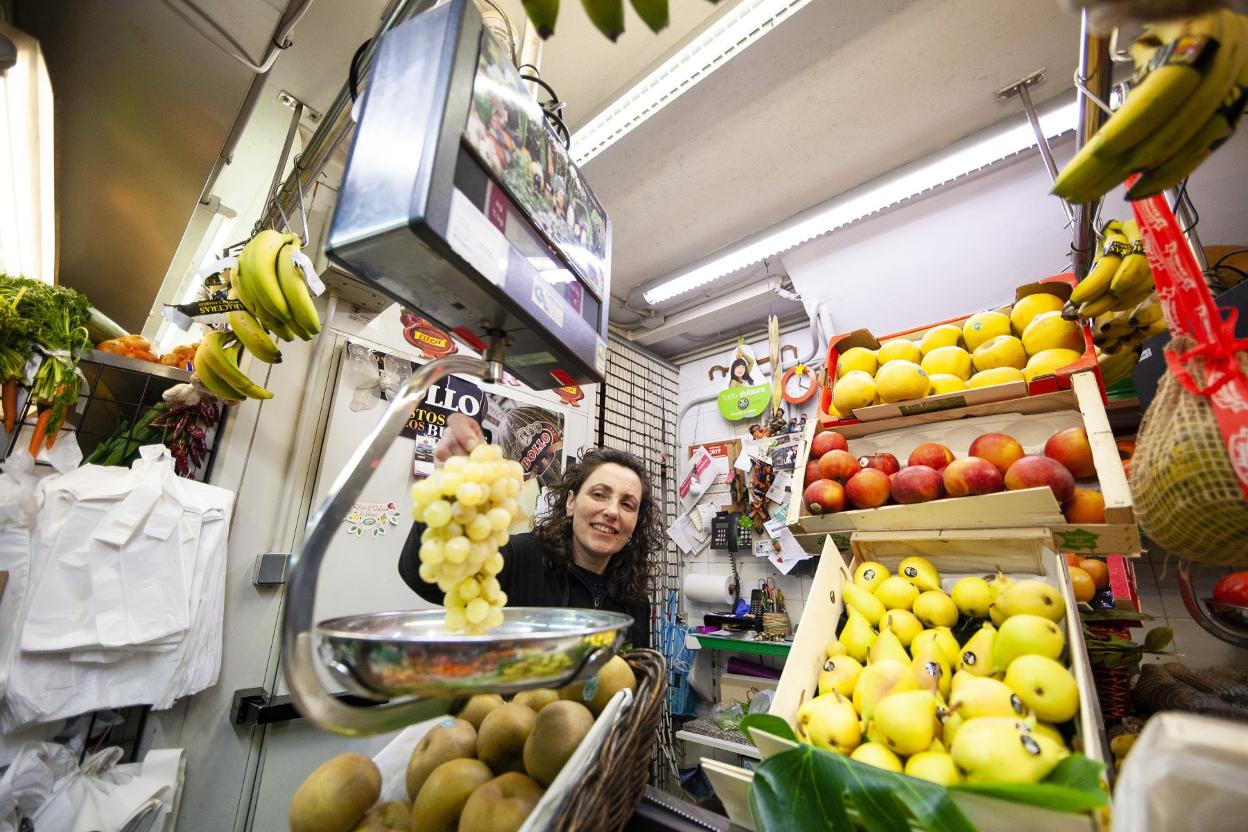 Flor Labrada, de Frutería Labrada, pesa un racimo de uva blanca.