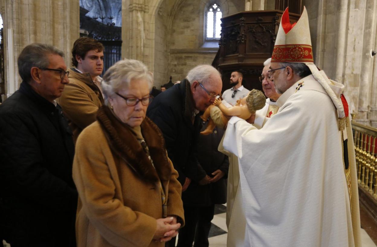 El arzobispo, Jesús Sanz Montes, con la imagen del Niño Jesús durante el besapiés. 