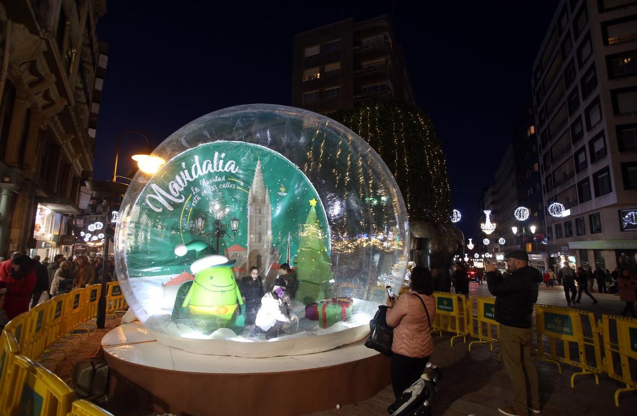 Una niña se divierte en la gran bola de nieve instalada en la calle Palacio Valdés en el seno de Navidalia. 