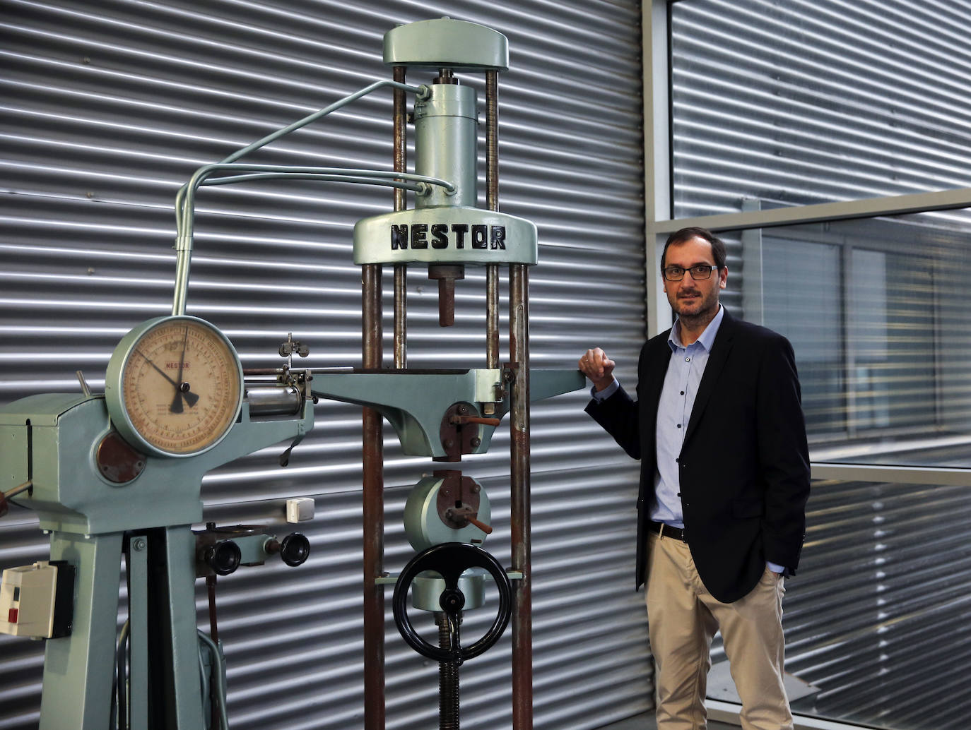 Íñigo Felgueroso junto a una antigua máquina de ensayos de tracción.