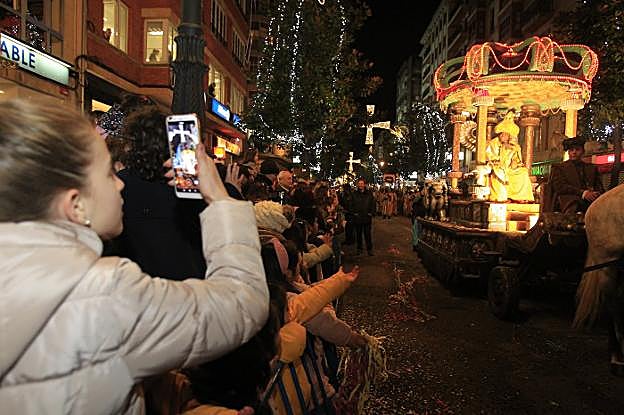 Una joven graba con un móvil el paso de Baltasar por la calle Uría mientras decenas de personas gritaban su nombre. 