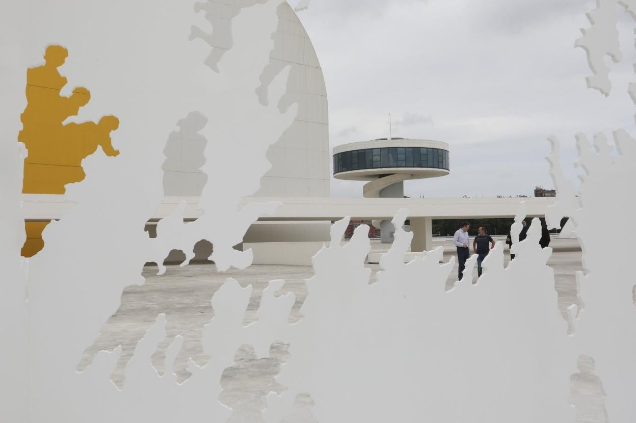 La torre y el auditorio del Centro Niemeyer vistos a través de la escultura de Genovés 'Transbase', situada en la plaza. 
