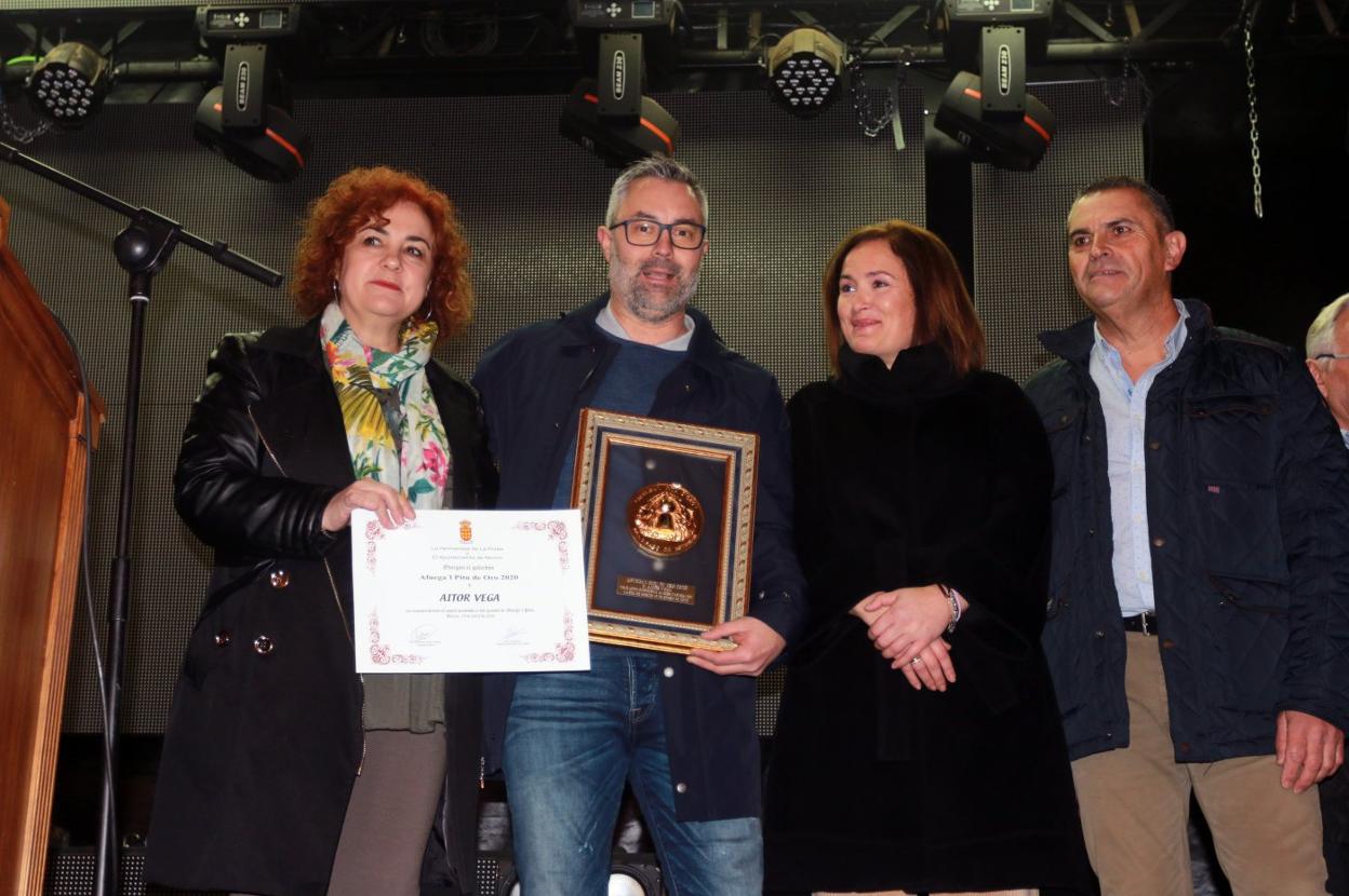 Aitor Vega recibe el Afuega'l pitu de Oro de manos de la presidenta de la hermandad, Nuria Ruiz, junto a la directora general de Desarrollo Rural, Begoña López, y el alcalde de Morcín, Maximino García. 