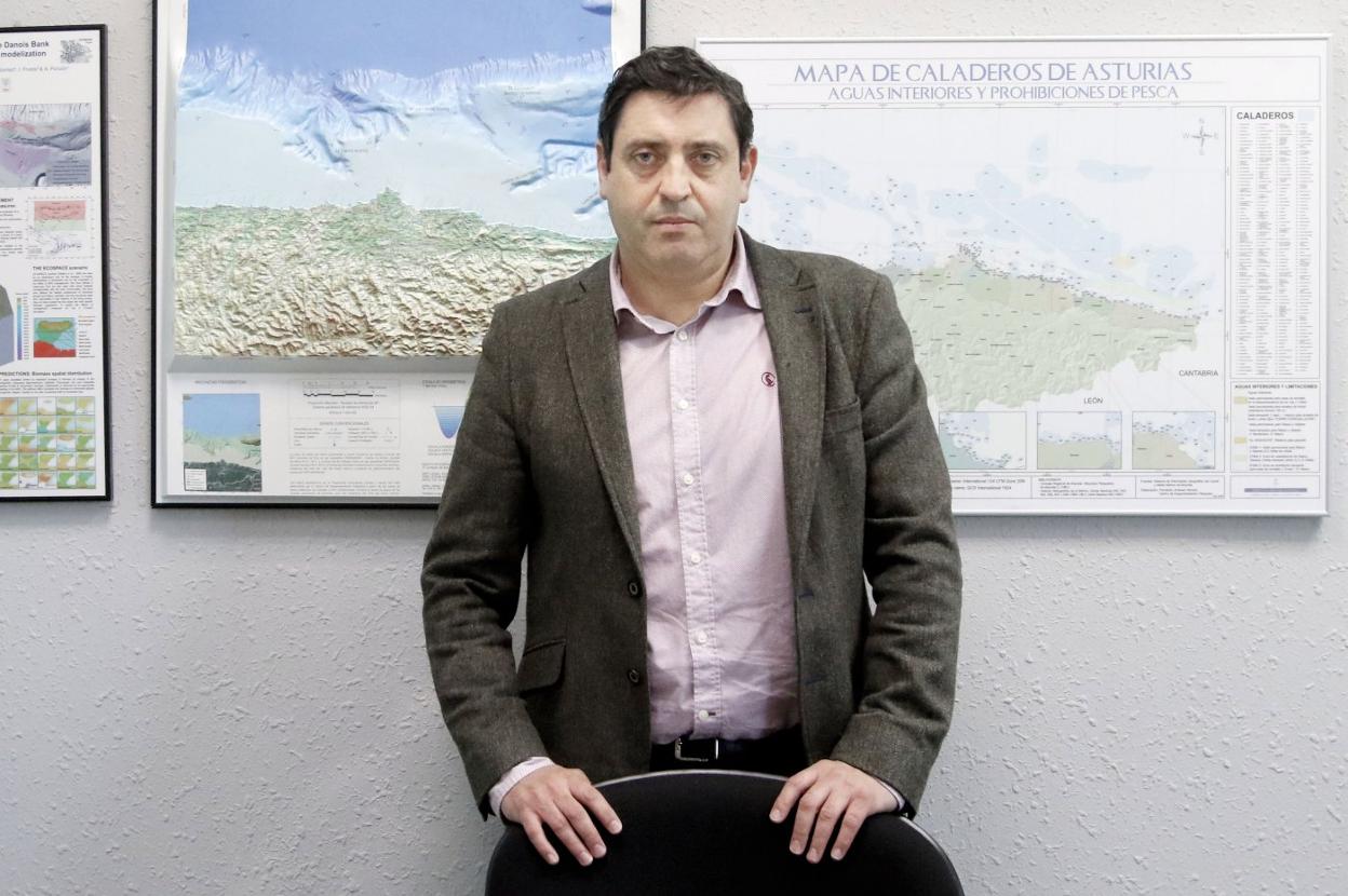 Francisco González, en su despacho de la Dirección General de Pesca Marítima, frente al mapa de caladeros asturianos. 