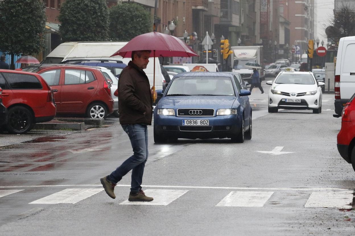 Un peatón cruza la avenidaTorcuato Fernández-Miranda cerca del cruce con la avenida Castilla. 